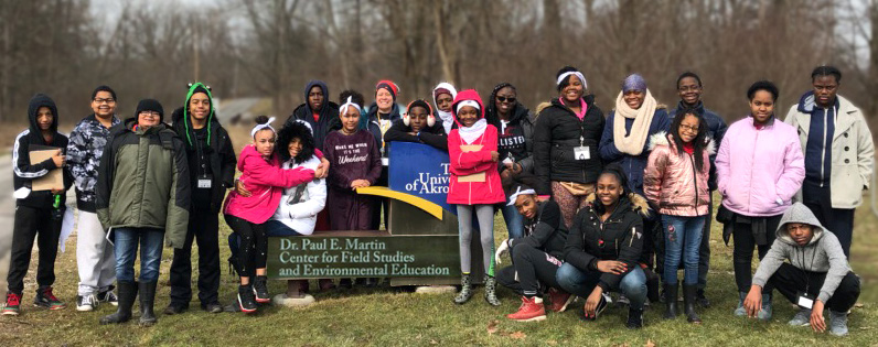 students from Akron Public Schools standing in front of the University of Akron Field Station sign